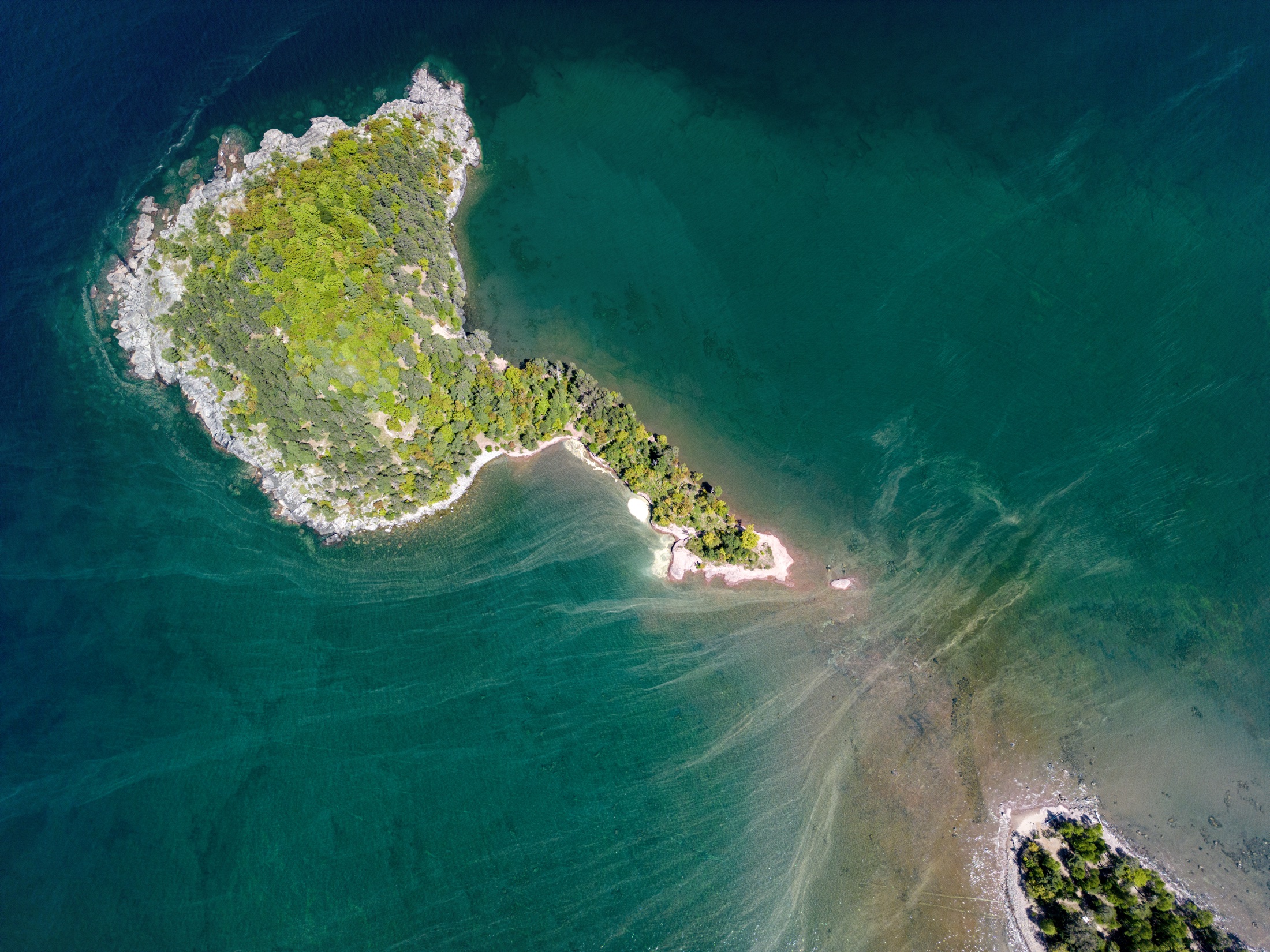 Aerial view of Little Presque island surrounded by green and blue water.