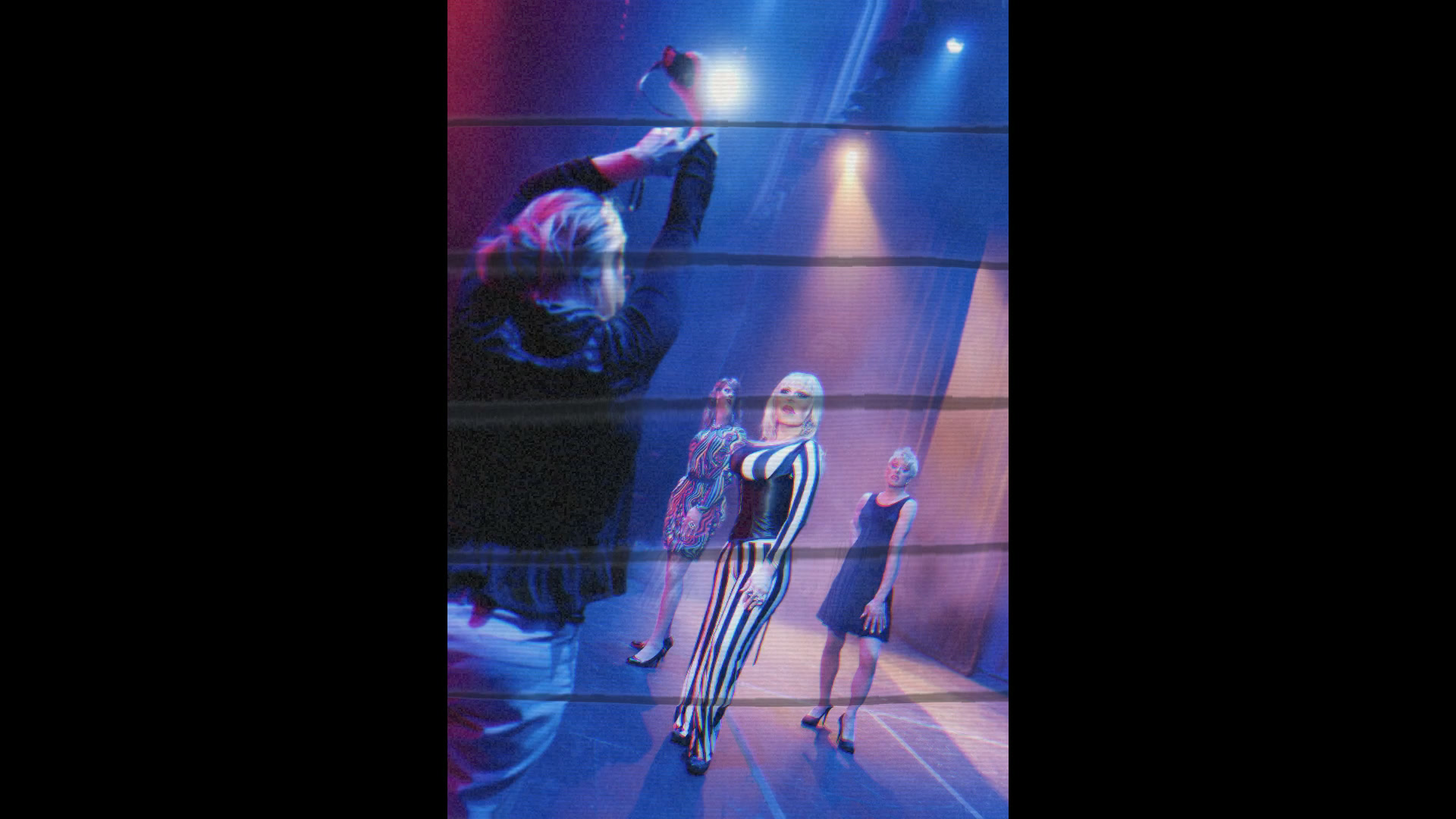 Performers under blue and magenta stage lighting appear through translucent horizontal ribbons, with the original portrait proportions preserved.